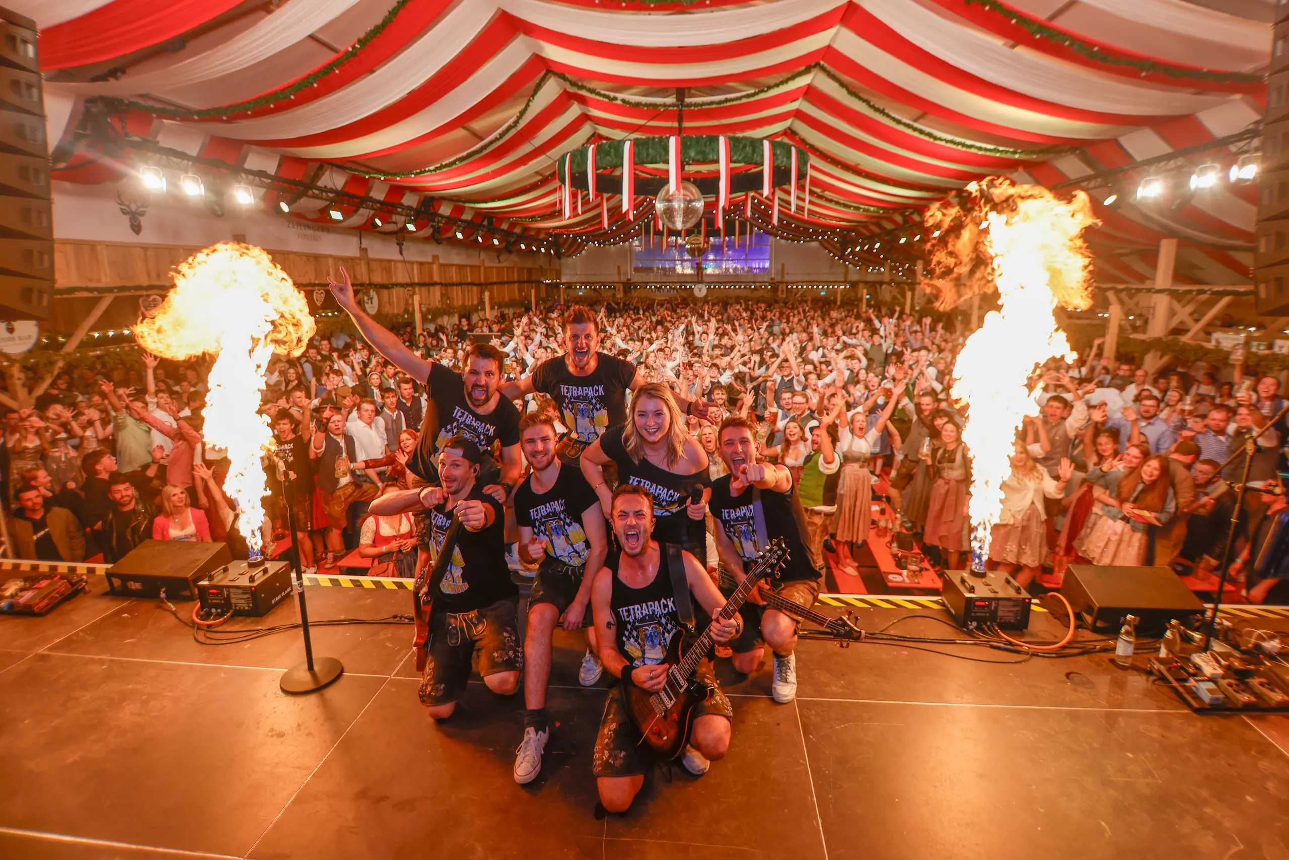 Die Band TETRAPACK auf der Bühne im Festzelt, links und rechts Flammensäulen