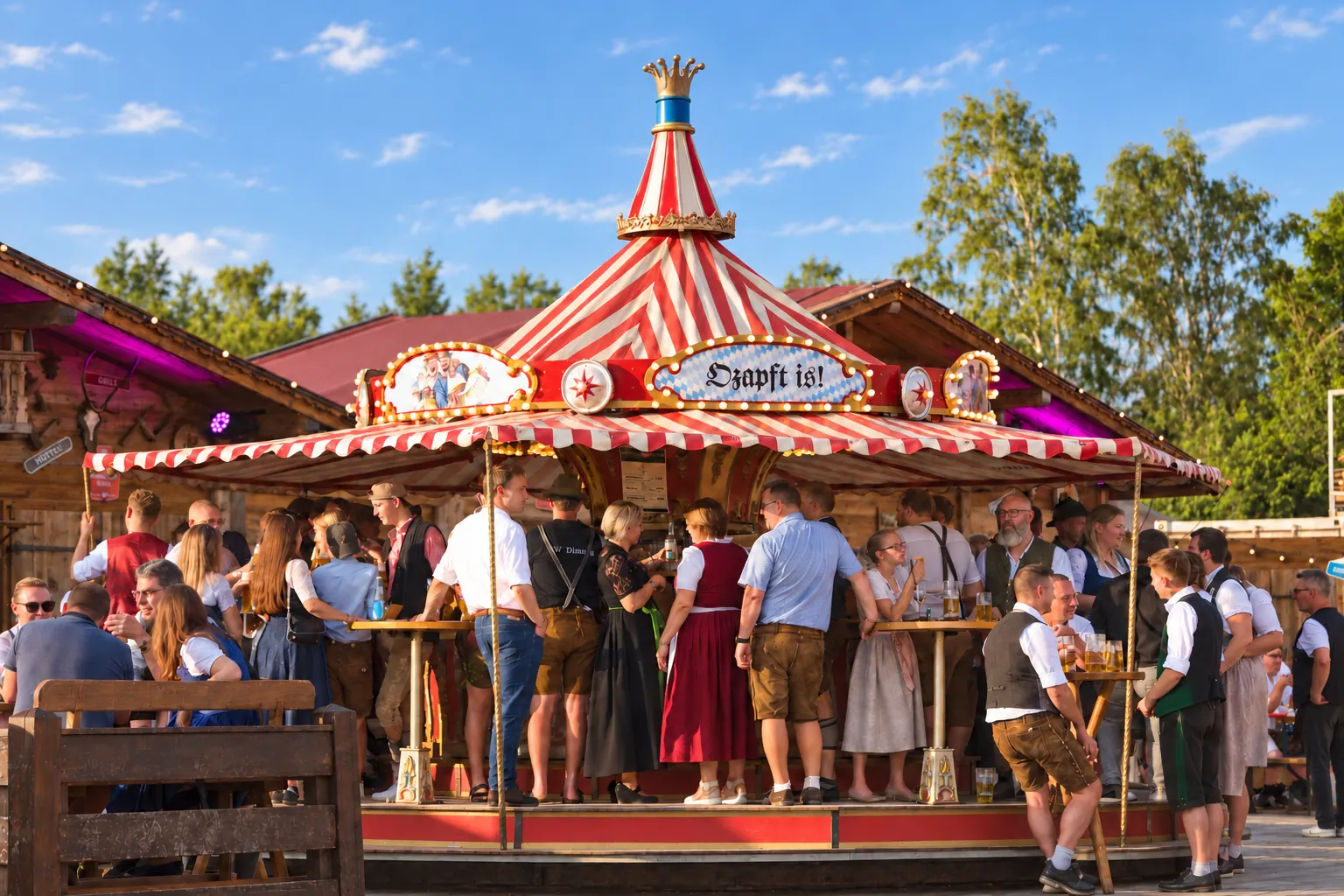 Das rot-weiße Nostalgie Karussell mit Gästen in Tracht